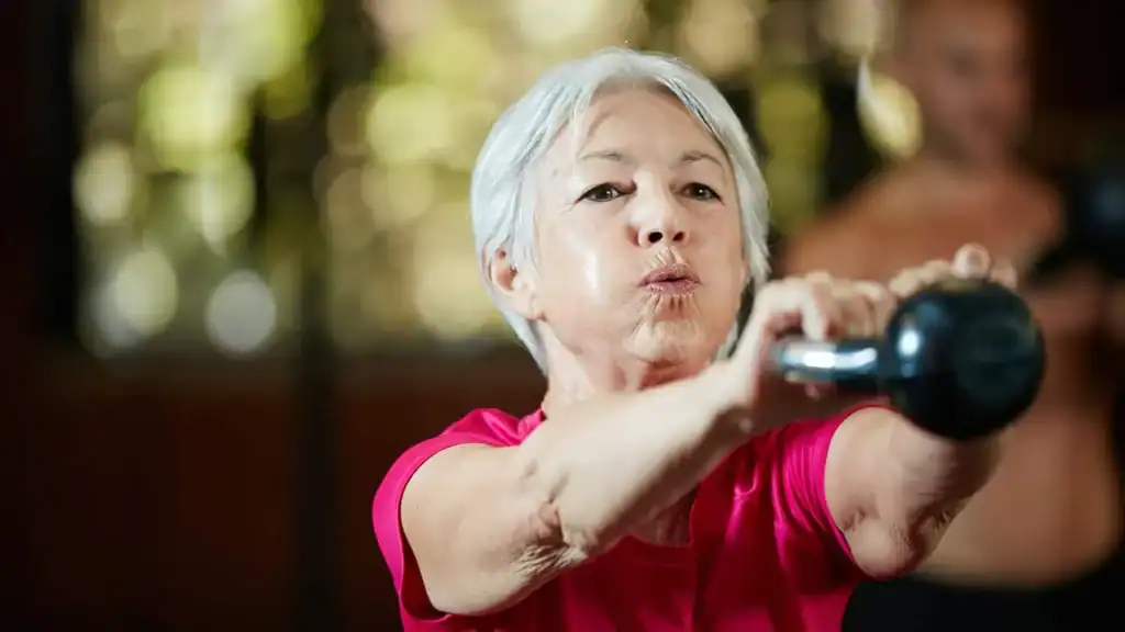 Older woman doing weight training Loughborough to help her strength and longevity 