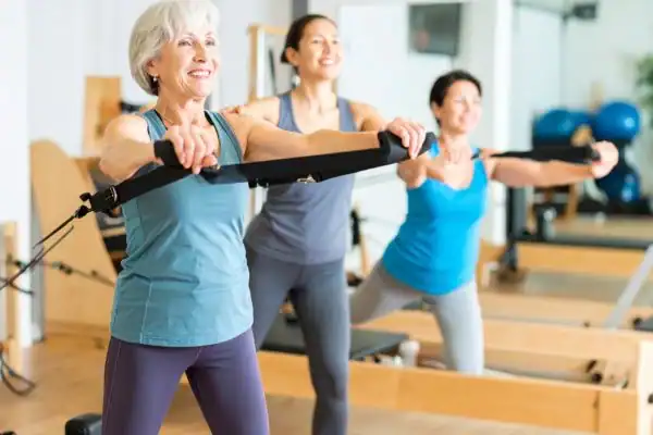 Toning Arms After 60: Empowering Womens Fitness Through Effective Weight Training 2 older woman doing weight training Loughborough and resistance in the gym to tone upper arms