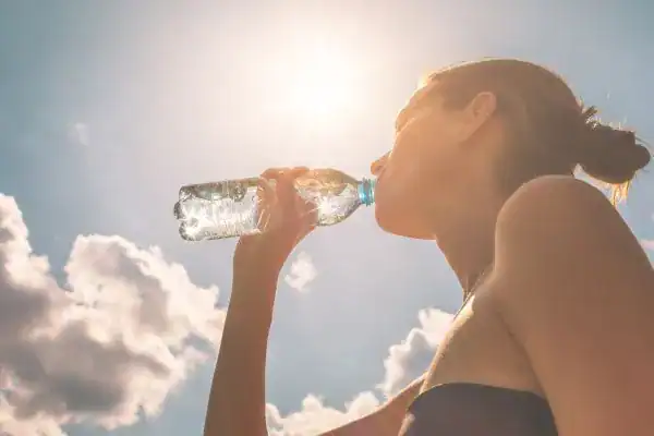 Hydration: The Secret Ingredient for a Toned Stomach and Enhanced Fitness 3 Image of woman drinking water to hydrate Loughborough after run.